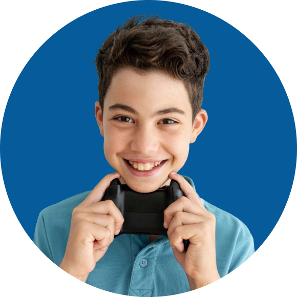 Boy in blue shirt smiling, holds a gaming controller against his chin, with a blue background.